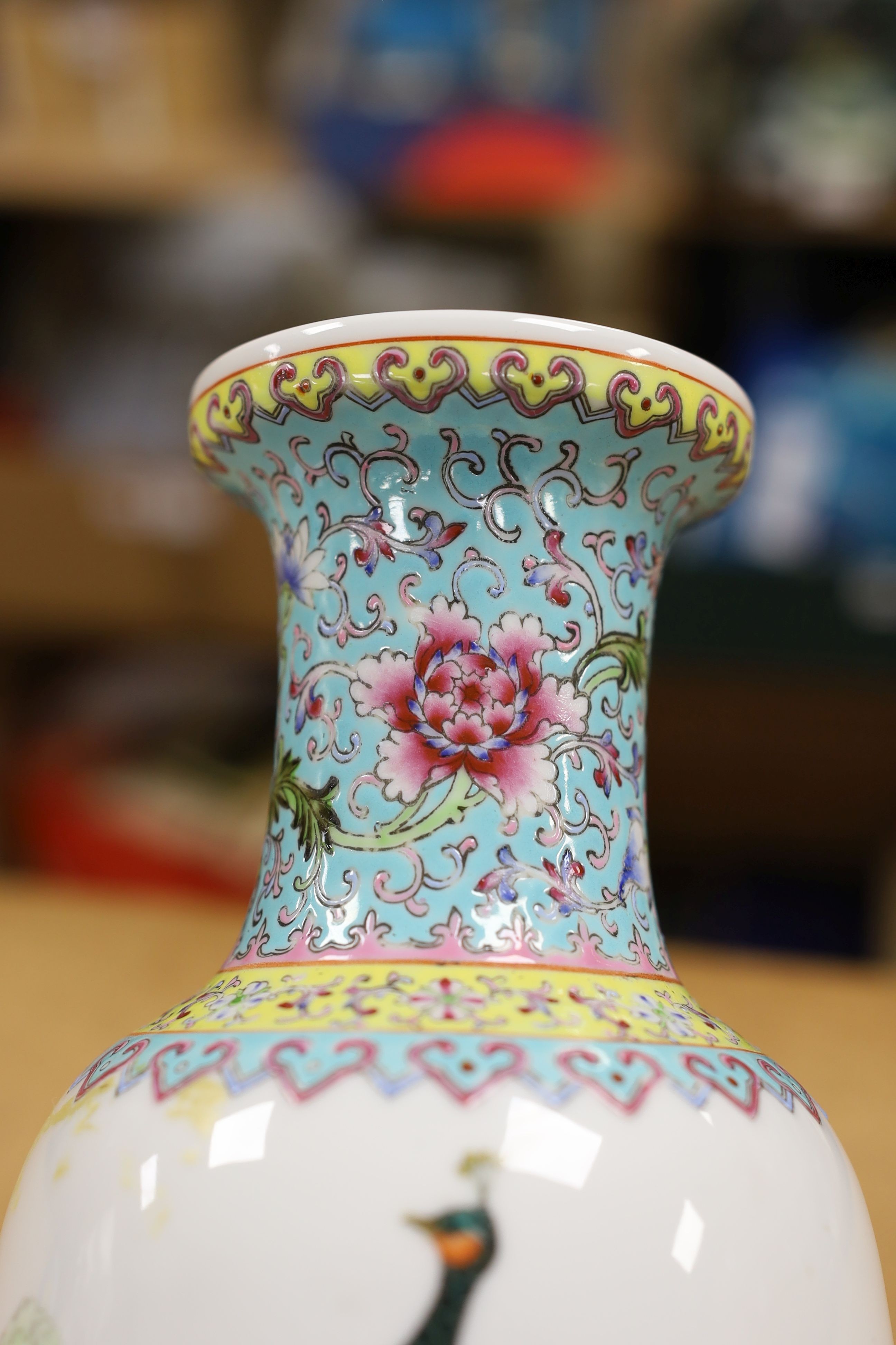 A pair of Chinese famille rose vases decorated with peacocks, 31cm